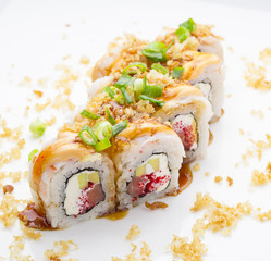 Sushi with shrimp avocado salmon and cheese strewed with green onion. Crunch Roll. With delicious sauces. Over white background.