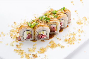 Sushi with shrimp avocado salmon and cheese strewed with green onion. Crunch Roll. With delicious sauces. On a plate over white background.