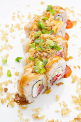 Sushi with shrimp avocado salmon and cheese strewed with green onion. Crunch Roll. With delicious sauces. Over white background.