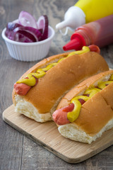 Hot dog with mustard and ketchup on a wood table
