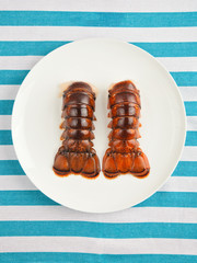 Two lobster tails on plate top view