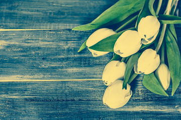White tulips flowers on wooden table with copy space, top view, vintage photo