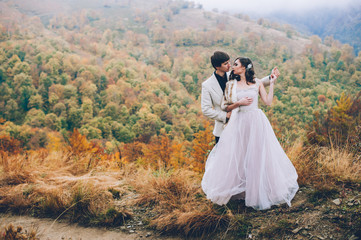 happy newly married couple posing in the mountains