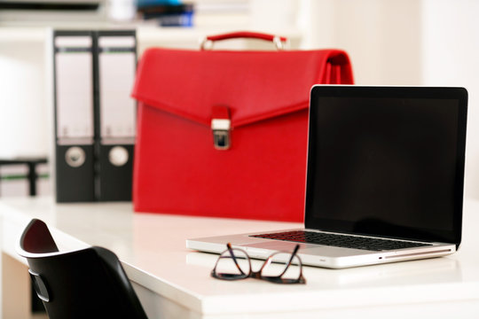Notebook am Arbeitsplatz mit roter Tasche