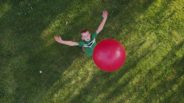 Boy throwing red ball, overhead shot