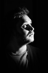 Fototapeta premium Young man's portrait. Close-up face against black background