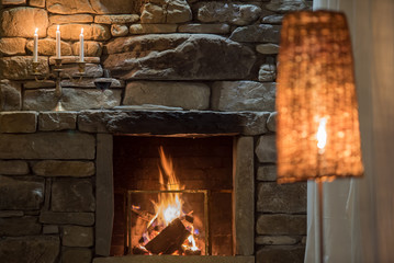 Relaxing stone fireplace with candle and red vine
