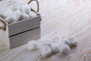 Cotton balls in a box on wooden table