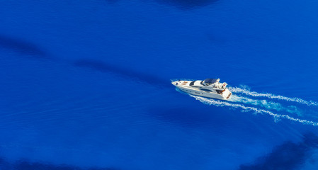 Naklejka premium Aerial view of single yacht in azure sea