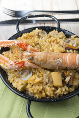 Vegetable paella with seafood on a wooden background