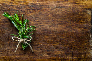 Rosemary bunch on rustic wood table, copy space