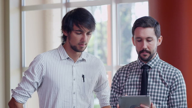 Two young businessmen with digital tablet