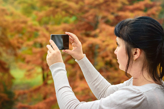 Woman taking pictures with mobile phone