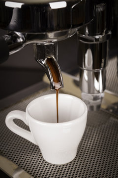 cup of espresso poured from a espresso machine 