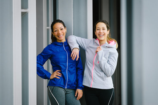 Two successful fitness women portrait before urban outdoor workout.