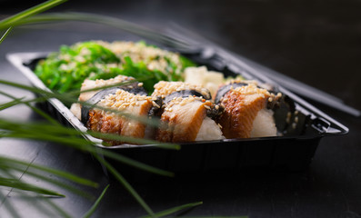 Sushi with smoked eel. Unagi nigiri and chuka salad with sauce a