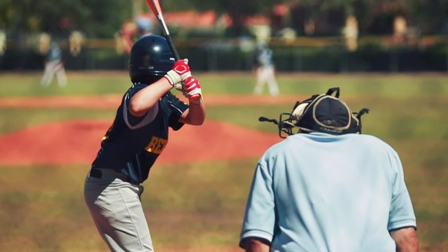 Slow motion of batter hitting ball and running to first during a baseball game