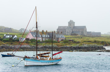 Vintage schooner sailboat with furled sails moored at Iona island natural port close to Mull, in...