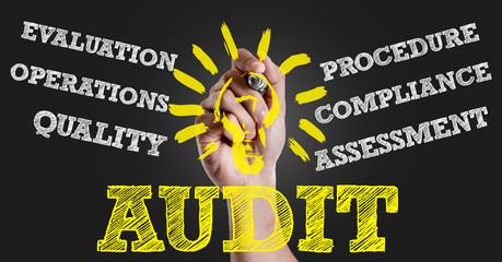 Hand writing the text: Audit