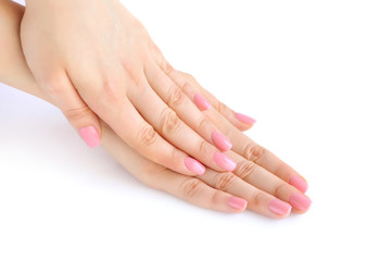 Closeup of hands of a young woman with pink manicure on nails against white background