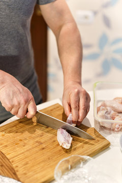 man preparing chicken wings to cook them
