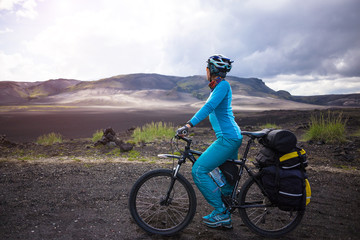 Fototapeta premium Happy biker on backdrop of volcanic mountains in Iceland