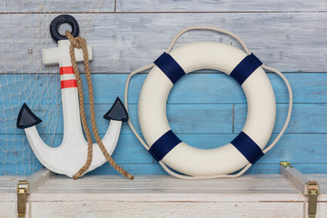 Anchor and life buoy on wood background blue-white