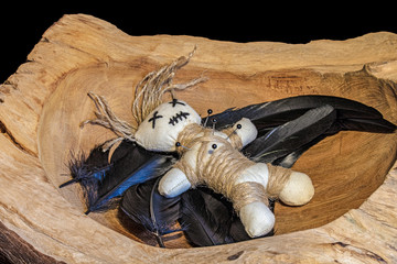 Voodoopuppe in einer Holzschale