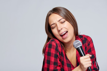 Emotional  girl singing a song in microphone
