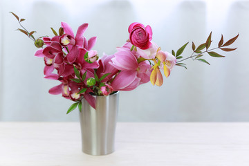 Beautiful flowers in vase on table against the window.