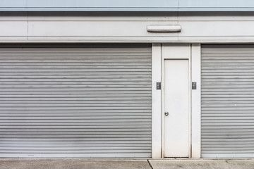 Fototapeta premium The steel doors of factory. There are panel and rolling doors.
