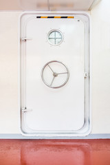 Fototapeta premium White closed watertight door in a ship. The door provides a functional barrier between watertight bulkheads.