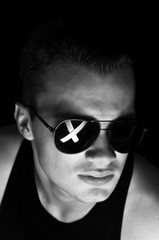 Obraz premium The guy in dark glasses with a cross