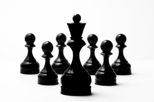Chess black king and six black pawns on a white background