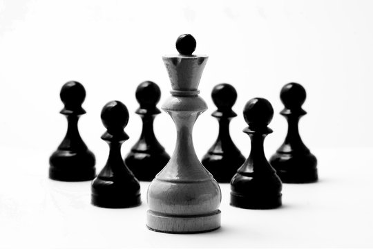 Chess white king and six black pawns on a white background in vintage