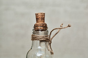 Obraz na płótnie Canvas decorative vintage bottle with a cork and a note inside on a gray background