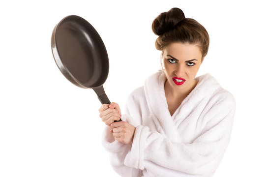 woman with a frying pan in a hand in white bathrobe