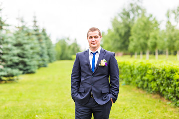Groom in suit on the nature. Male portrait outdoors. Handsome guy outdoors 