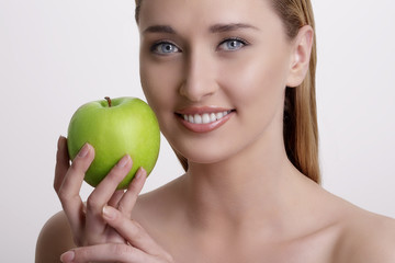 fresh young woman showing a green apple