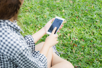girl sitting in garden and use smart phone