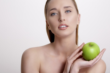 Obraz na płótnie Canvas fresh young woman showing a green apple
