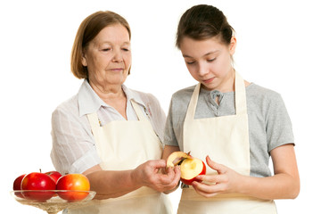 the grandmother teaches the granddaughter to cut off a peel from