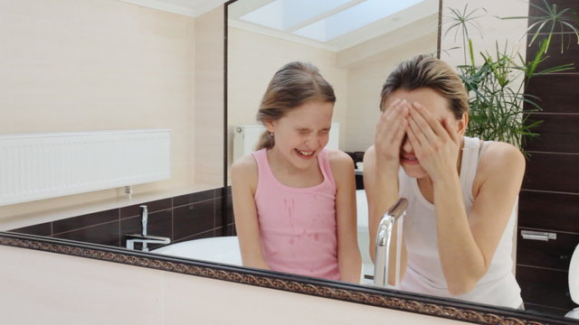 Mother and daughter in the morning wash in the bathroom