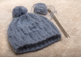 Fototapeta na wymiar knitted baby hat with bells of blue mohair