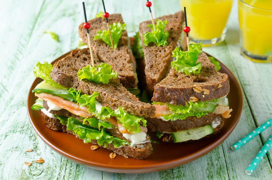 Club sandwich with salmon and cucumbers