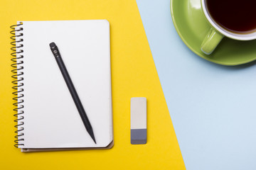 Office desk table with supplies top view. Notepad, pen and colorful paper. Copy space for text