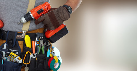 Builder handyman with drill. - obrazy, fototapety, plakaty