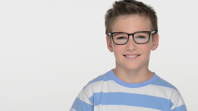 Pretty  boy of ten years, wears glasses, looks at the camera and smiles