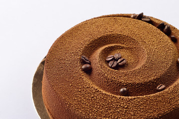 Fototapeta na wymiar chocolate-coffee cake with grains of coffee on a gold substrate,