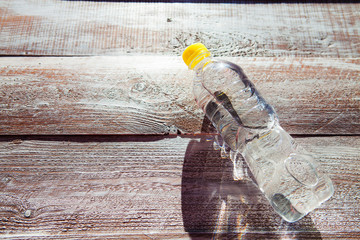 a bottle with water is isolated on a wooden background